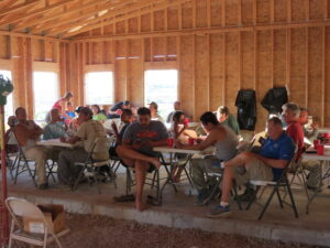 Mens Program Bible Study with members sitting at tables in a group setting.